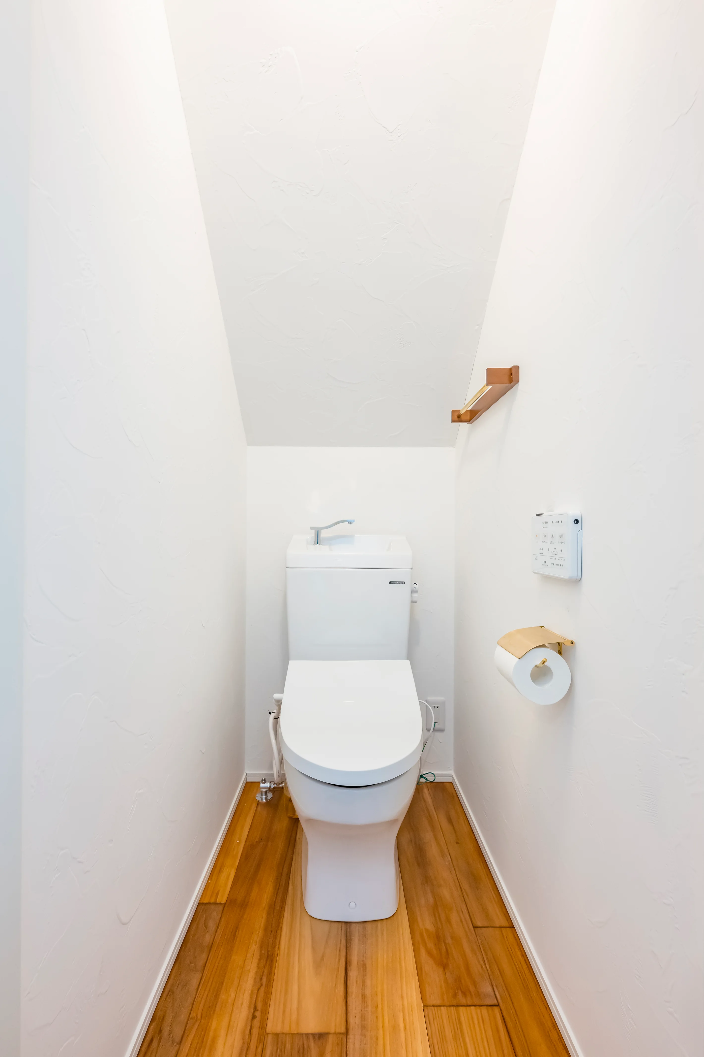 白い壁と天井の質感が見えるトイレ空間の施工事例